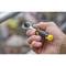 A hand is holding a spanner with a yellow and black handle. Background blurred, focus on the tool.