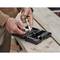 A person is repairing something with a spanner from a toolbox on a wooden table.