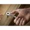 A hand is tightening a screw into a wooden board using a ratchet spanner.