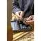 A person selects a socket spanner from a toolbox. The box is situated on a building site with bricks in the background.