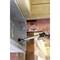 A person is tightening a screw on a metal bracket with a spanner to secure a wooden structure.