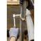 A person wearing gloves is repairing a metal pipe with an adjustable spanner and a hammer; focus on tools.