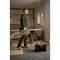A man is carrying a toolbox in an unfinished workshop with windows. Sawhorses and tools are visible in the background.