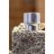Close-up of a silver socket wrench with the inscription '30', resting on a concrete block, with a blurred background.