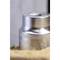 A silver, metallic bottle with an embossed pattern, partially obscured, stands vertically in close-up.