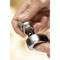 A hand holds a metallic doorknob component with a screw, ready for installation. Focus on the precision work with tools.