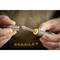 A person is holding a screwdriver with a bit in their left hand and a socket in their right hand. Background blurred.