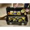 An open toolbox on a floor with yellow electric tools and sorted boxes of screws, nails, and wall plugs. A hand reaches for a small box of screws.