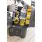 A hand reaches for a screw box from an open toolbox filled with a cordless drill and various screws.