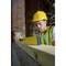 A construction worker wearing a hard hat and high-visibility vest is checking the levelness of a wooden beam on a building site.
