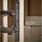 A person is holding a spirit level against a wooden beam to check the vertical alignment during the construction of a building.
