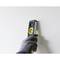 A person is holding a spirit level against a wall to check its straightness. The person is wearing gloves and the wall is light-coloured.