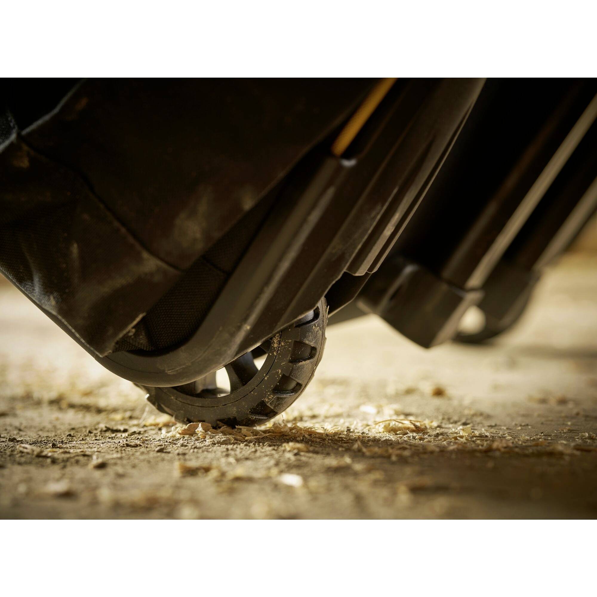Close-up of a car boot on uneven ground, stirring up dirt particles and demonstrating the off-road capability of the wheels.