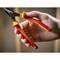 A hand is holding a red combination pliers with yellow accents, featuring the words 'Stanley' and 'Fatmax'. The pliers are partially open.