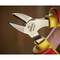 A yellow and red pair of wire cutters with open jaws, used for cutting wire. They are lying on a blurred surface.