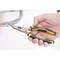 A hand is holding a small, yellow-black padded combination pliers with the inscription "Stanley".