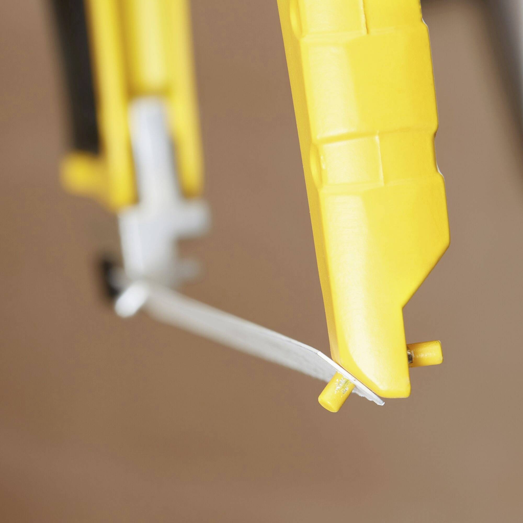 A yellow craft knife with an extended blade, shown in close-up.