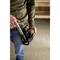 A tradesman is carrying a black tool bag with a hammer and other tools being taken out.