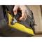 A hand pulls on a yellow strap of a bag, emphasising the bag's robust and functional design.
