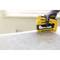 A hand wearing a glove is using a yellow staple gun to secure a wire mesh on a wooden table.