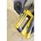 A person wearing work gloves is loading staples into a yellow staple gun, which is positioned on a carpet, prepared for DIY work.