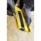 A person is wearing grey gloves and is loading staples into a yellow staple gun, presumably for construction or DIY work.