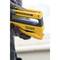 A person is holding a yellow hand stapler, ready for use. The focus is on the device used for DIY or craftwork.