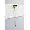 A broom hangs vertically on a white, textured wall. The broom handle is made of wood, and the bristles are dark.