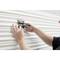 A person is cleaning a ridged white surface with a scraper. The scraper is black with a 'STANLEY' logo at the top.