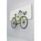A green bicycle hangs on a wall mount in a minimally furnished room.