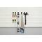 Tools hang on a ribbed wall board: two screwdrivers, three pliers, a spirit level, a saw and a hammer.