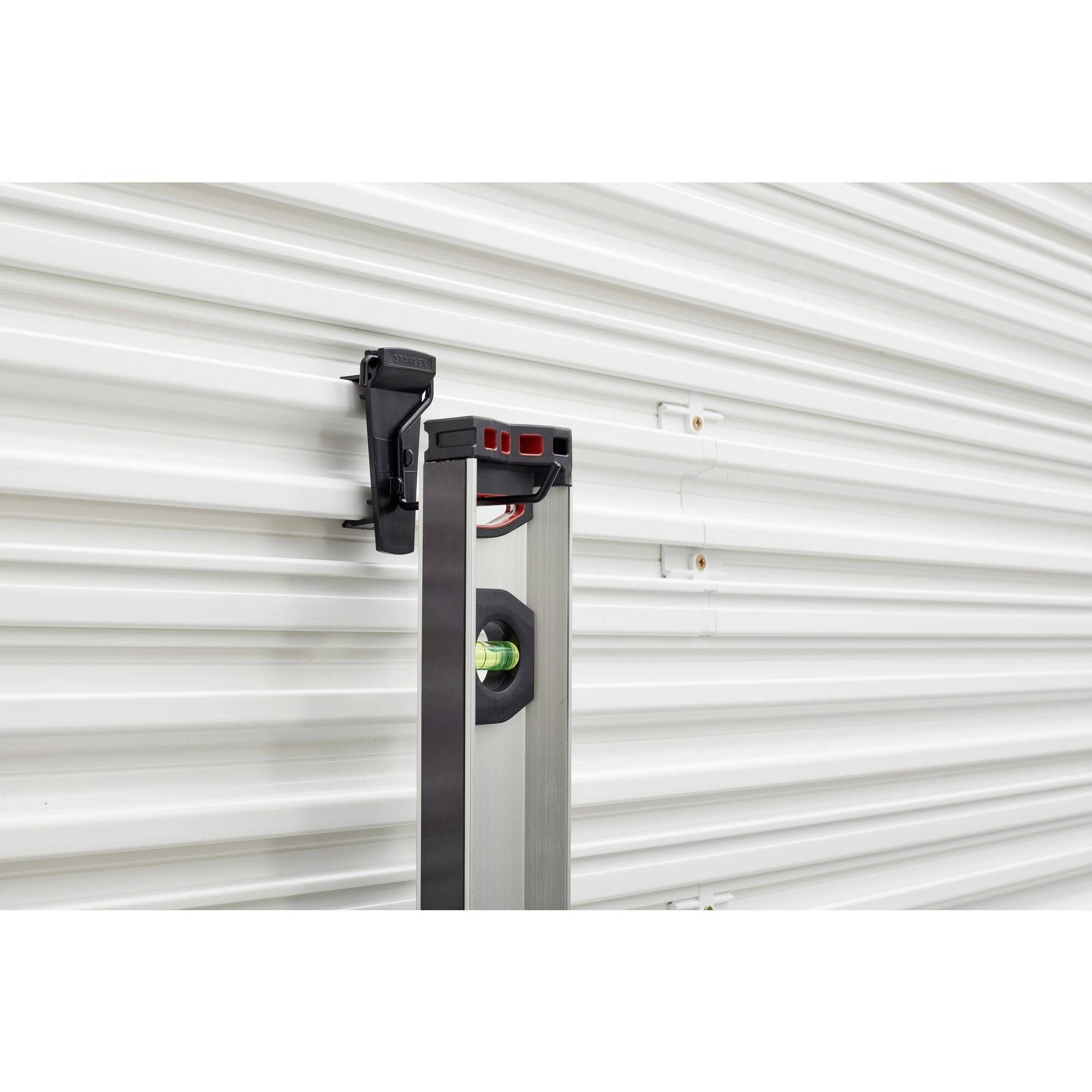 A spirit level measures the angle of inclination on a corrugated metal surface. The bubble indicates that the surface is not level.