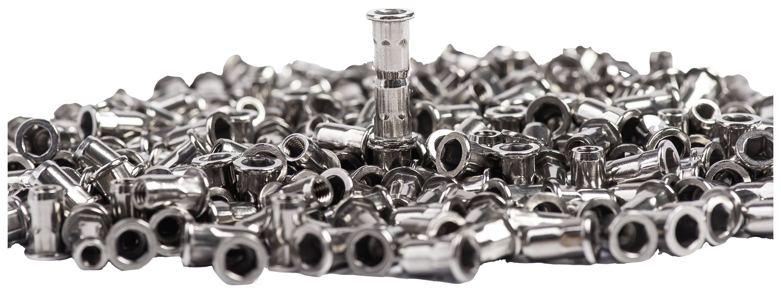 A single metallic plug stands upright amidst many horizontal plugs on a white background.