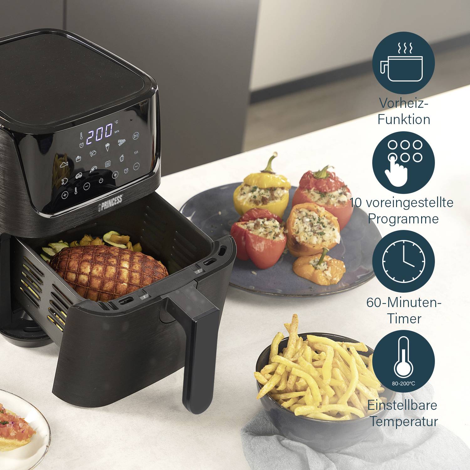 A black air fryer on a kitchen worktop, with chips in the basket. Stuffed peppers are positioned beside it. Symbols indicate functions: Preheat function, 10 programmes, 60-minute timer, adjustable temperature 80-200°C.