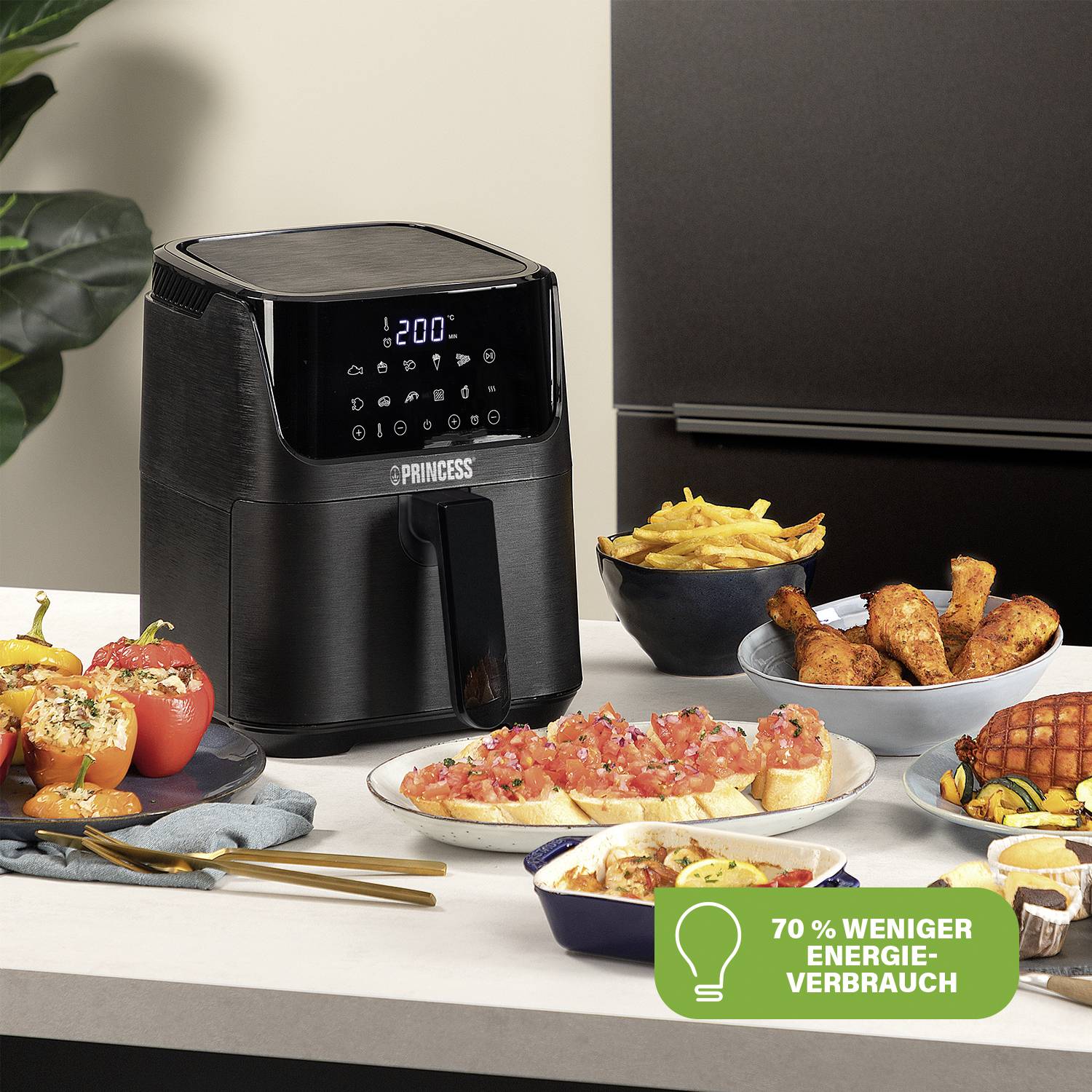 A black air fryer on a table next to various dishes. A badge displays '70% less energy consumption'.