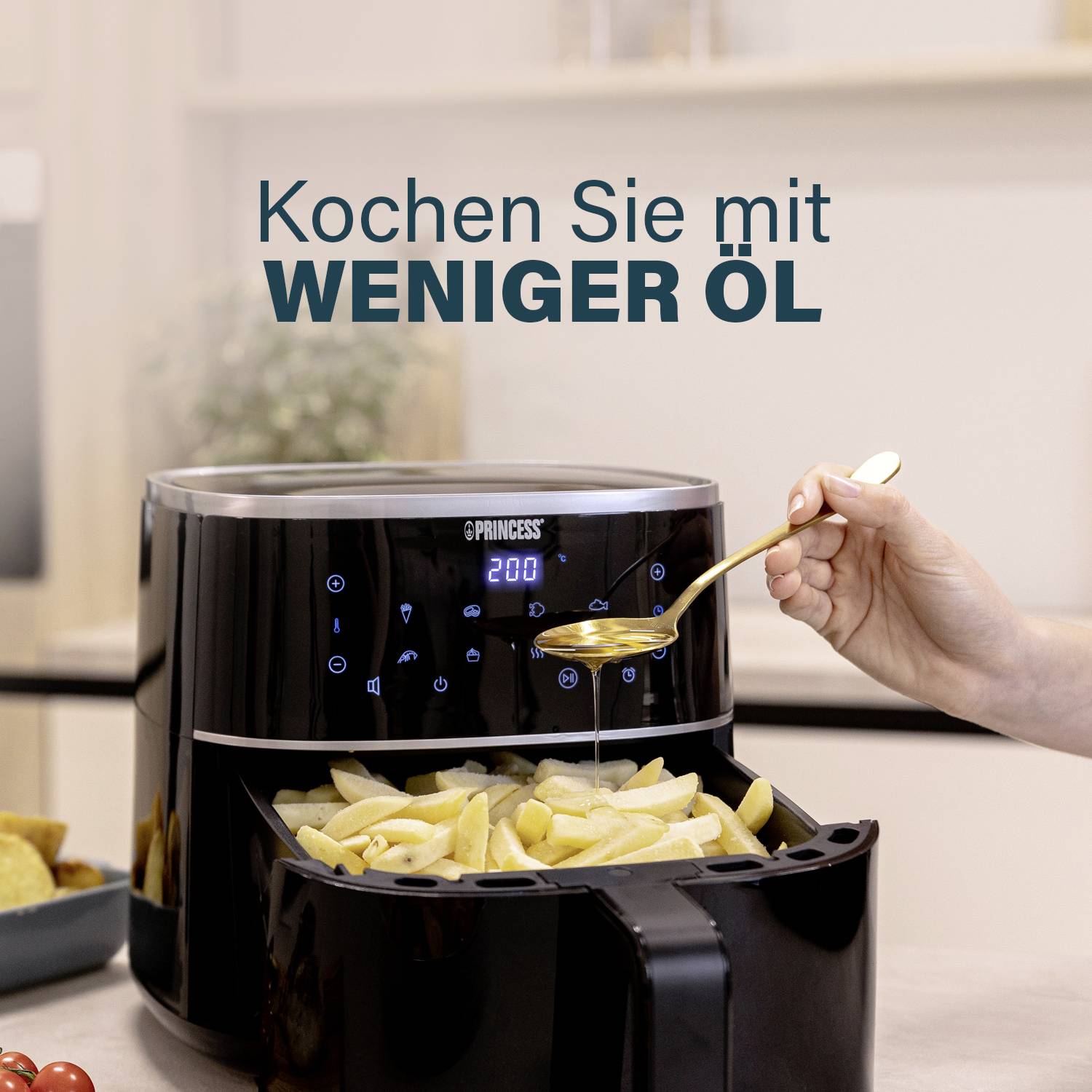 A hand is holding a spoon over an air fryer, with chips protruding from it. Text: 'Cook with less oil'.<br><br>Note: In British English, 'Pommes Frites' would typically be referred to as 'chips', and the translation uses British English phrasing and spelling.