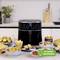 An air fryer on a kitchen worktop, surrounded by various snacks such as chips and pastries. Green symbol: '60% less energy consumption'.