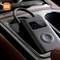 A portable air compressor from Xiaomi sits in a car's glove compartment, with its digital display and control buttons clearly visible.