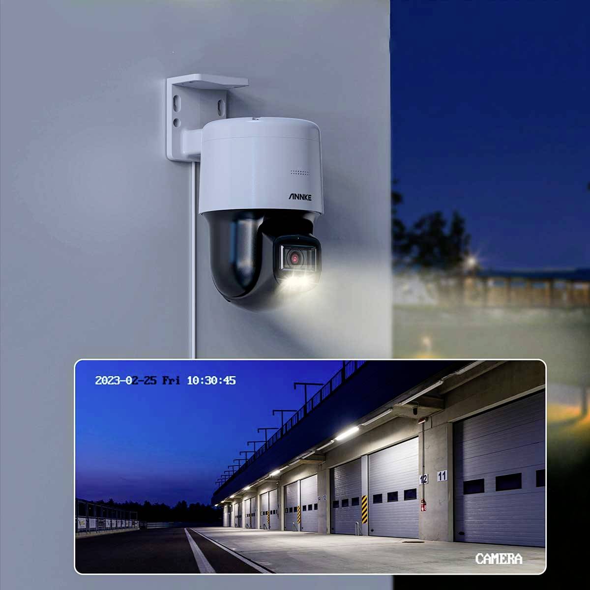 Surveillance camera with live feed showing exterior view of a warehouse at night. Date and time displayed in the top left corner.