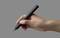 A hand holds a black marker against a grey background.