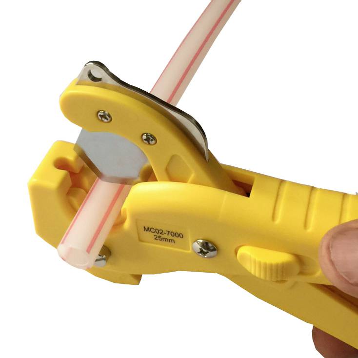 Yellow tool cuts a plastic pipe. The pipe is white with a red stripe. The tool has a cutting mechanism and a scale.