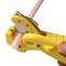 Yellow tool cuts a plastic pipe. The pipe is white with a red stripe. The tool has a cutting mechanism and a scale.