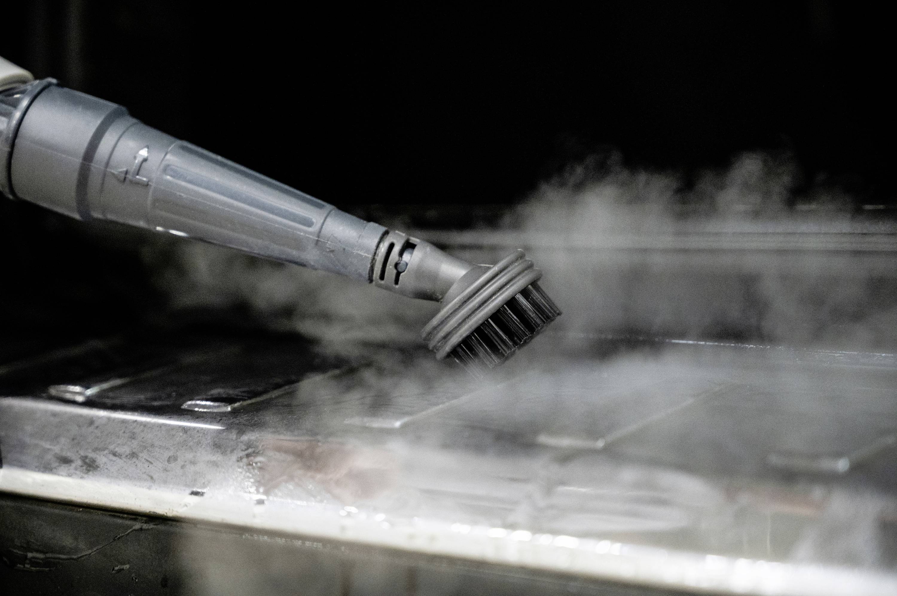 Brush attached to steam cleaner cleans oven surface with steam. Dirt and grease are dissolved. An efficient cleaning method.
