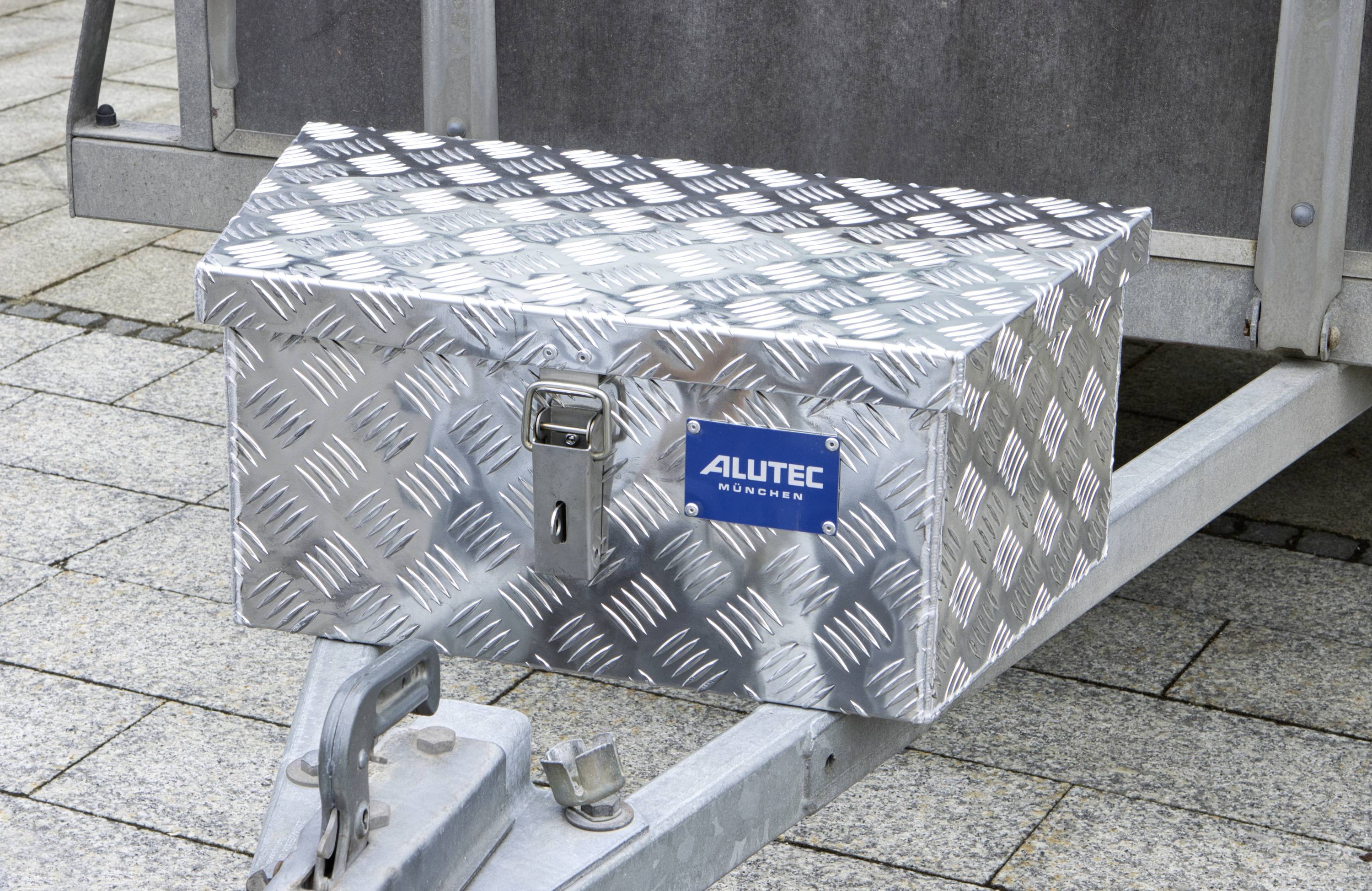 Aluminium tool chest with hinges and a lock mounted on a vehicle, used for securely storing tools and equipment.