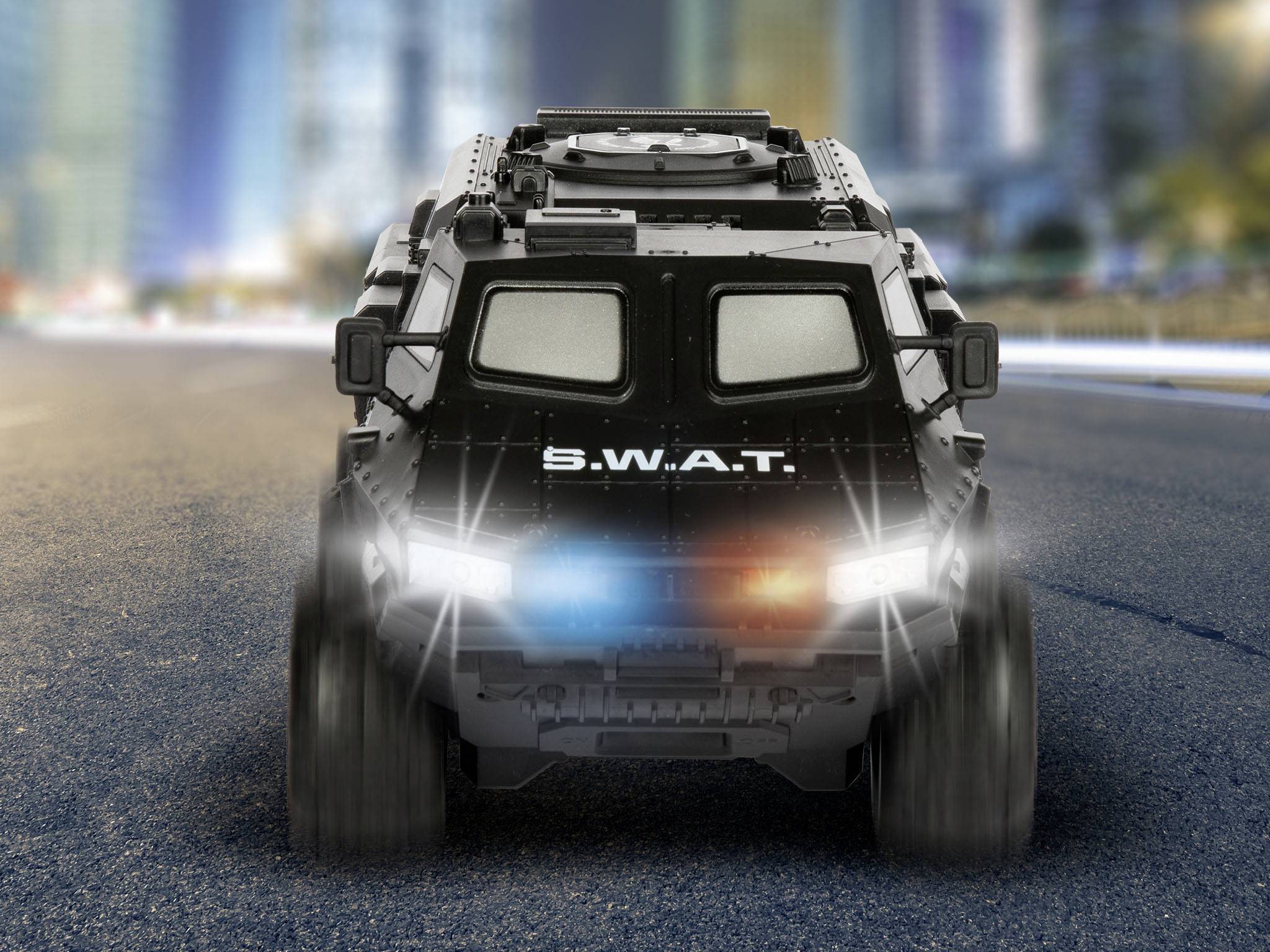 An armoured SWAT vehicle with flashing blue lights drives along an urban street. Background blurred with high-rise buildings.