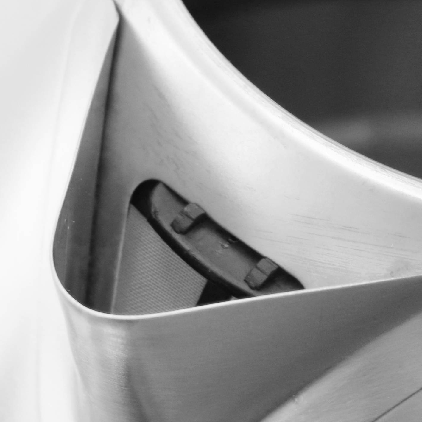 Metallic object with a polished surface, captured in close-up with two visible rivets.