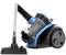 A blue and black bagless vacuum cleaner with a transparent container and suction tube, standing on two large wheels.