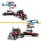 A red toy articulated lorry set with a detachable helicopter on the trailer, assembled from building blocks.