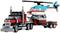 A Lego set shows a red lorry with a trailer, transporting a blue helicopter.