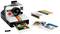 A LEGO camera in the Polaroid style with a printed photograph. Next to the camera are a box and two additional pictures.